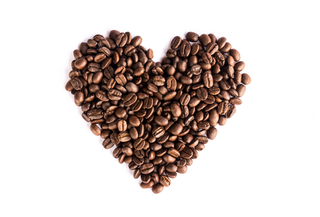 Coffee beans arranged as a heart shape on white backgroundの写真素材