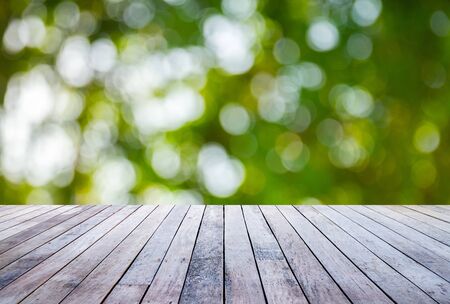 Wood plank with abstract natural green blurred bokeh background for product displayの写真素材