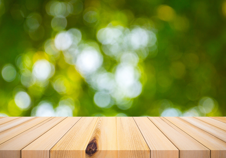 Wood plank with abstract natural green blurred bokeh background for product displayの写真素材