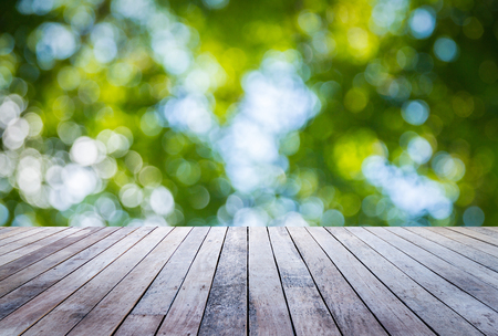 Old wood plank with abstract natural green blurred bokeh background for product displayの写真素材