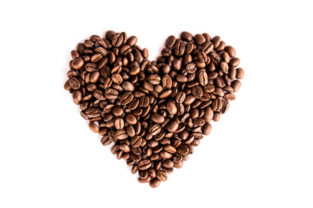 Coffee beans arranged as a heart shape on white backgroundの写真素材