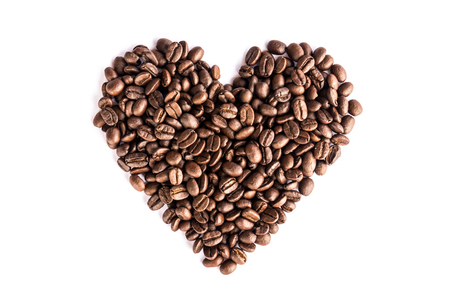 Coffee beans arranged as a heart shape on white backgroundの写真素材