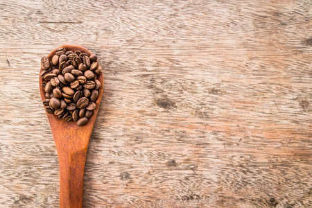 Coffee Beans in wooden spoon on old wood backgroundの写真素材