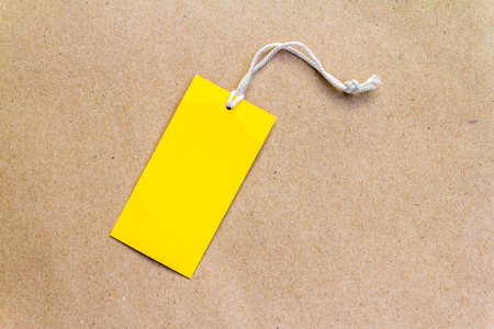 Emtry yellow price tag on brown paper backgroundの写真素材