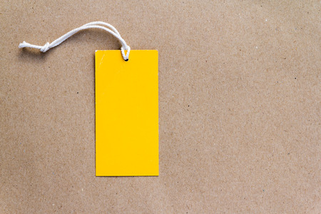 Emtry yellow price tag on brown paper backgroundの写真素材