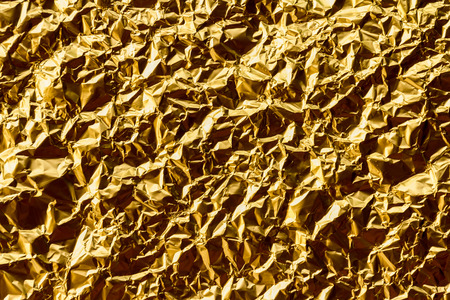 Crumpled gold foil texture backgroundの写真素材
