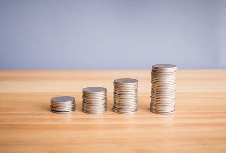 stacks of coin on wooden desk with grey background concept saving moneyの写真素材