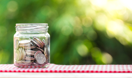 Money coin in glass jar concept for saving moneyの写真素材