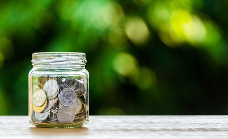 Money coin in glass jar for savings and financial investment conceptの写真素材