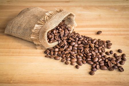 Sack of coffee beans on wooden backgroundの写真素材