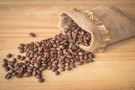 Sack of coffee beans on wooden backgroundの写真素材