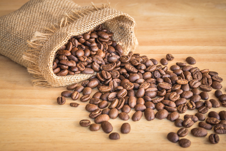 Sack of coffee beans on wooden backgroundの写真素材