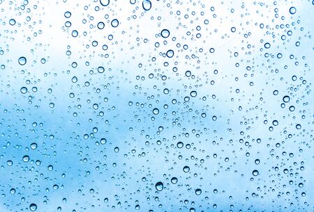 Blue water drops on glass or rain drop backgroundの写真素材