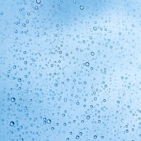 Blue water drops on glass or rain drop backgroundの写真素材