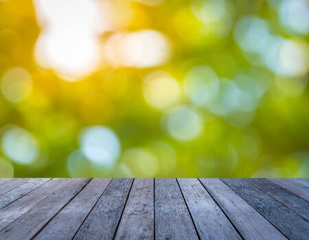 Old wood plank with abstract natural green blurred bokeh background for product displayの写真素材