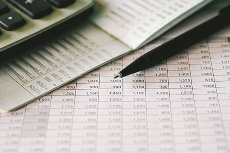 Pen and Calculator on accounting report, Business and Financial concept.