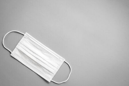 White Medical protective mask or Surgical face mask on grey background with copy spaceの写真素材