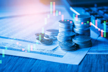 Stack of money coin on accounting sheet with trading graph, financial investment concept.の写真素材