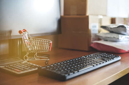 Close up of computer keyboard with small shopping cart, calculator and Pakaging box, Ecommerce Concept.の写真素材