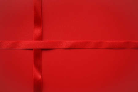 Red satin ribbon across red background, Love or Gift background conceptの写真素材