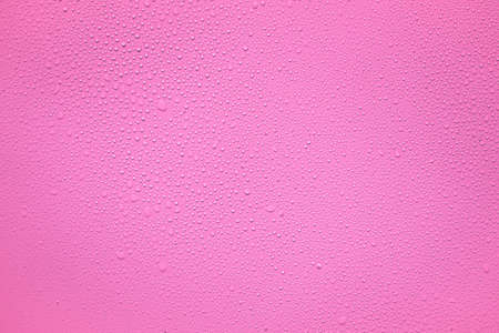Water or rain drops on pink plastic sheet backgroundの写真素材
