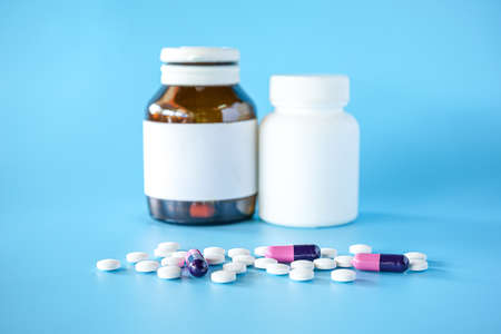 pill bottle with teblets pills on blue background with selective focusの写真素材