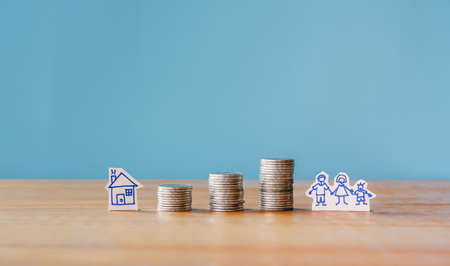 Stack of money coin on wood desk and blue background, Finance concept or Saving money for family,...
