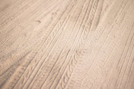 motorcycle and car tire track print on sand with selective focus