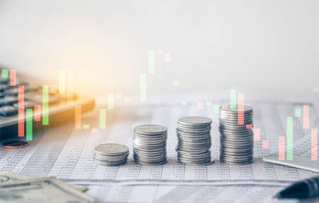 Stack of money coin with trading graph, Business and financial investment concept can be use as backgroundの写真素材