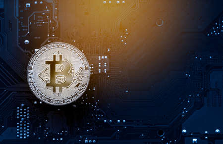 Gold bitcoin on computer mainboard with trading graph, Mining and trade bitcoin concept.の写真素材