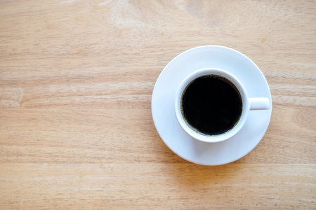 Top view of dark hot coffee cup on wood desk with copy spaceの写真素材