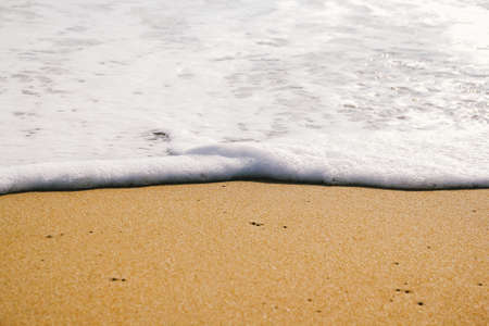 Ocean wave on sandy beach backgroundの写真素材