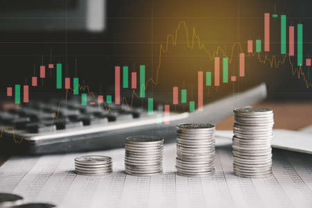 Stack of money coin with trading graph, financial investment concept can be use as backgroundの写真素材