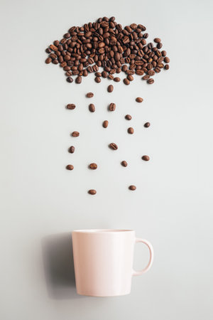 Coffee beans flying out of a coffee cup on a gray backgroundの写真素材