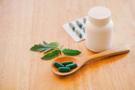 Herbal medicine pills on wooden spoon with copy space for text.の写真素材