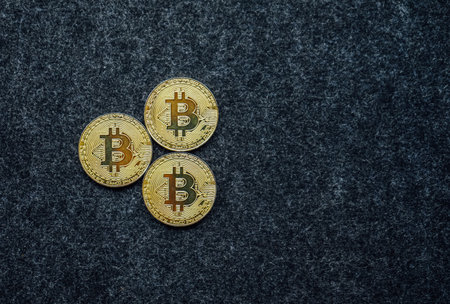 Golden bitcoin on black background. Cryptocurrency and finance concept.