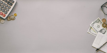 Top view of calculator, money and glasses on gray background with copy spaceの写真素材