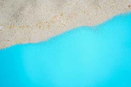 White sand on the beach with blue water background. Top view.の写真素材