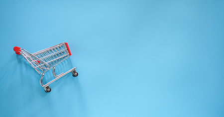 Shopping cart on a blue background with copy space. 3d renderingの写真素材