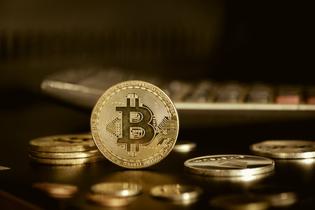Bitcoin on a background of coins and calculator. Close-up.の写真素材