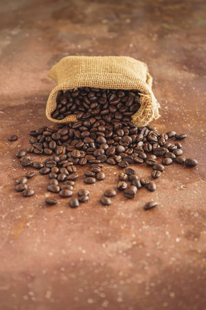 Coffee beans in a burlap bag on rustic backgroundの写真素材