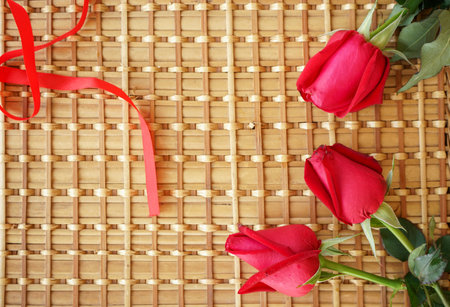Red roses on a bamboo mat. Valentine's Day background with copy space.の写真素材