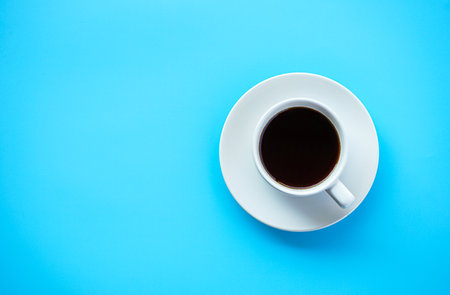 Coffee cup on blue background. Top view with copy spaceの写真素材