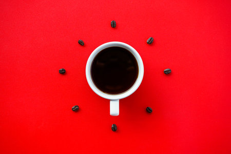 Coffee cup and coffee beans on red background top view.の写真素材