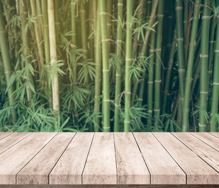 Wooden table top on blur bamboo background - can be used for display or montage your productsの写真素材
