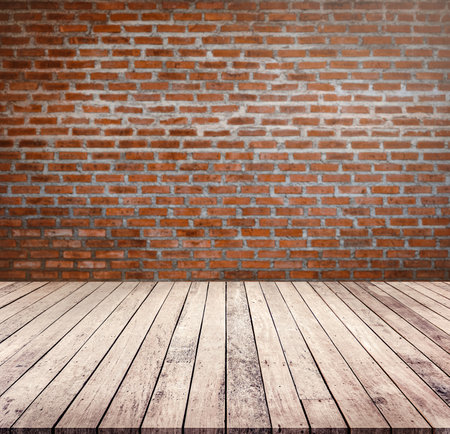 Wooden floor in front of red brick wall with copy space.の写真素材