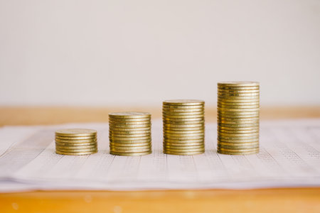 Stacks of gold coins on white paper, finance and banking conceptの写真素材