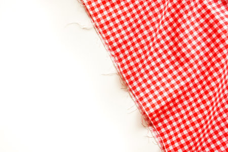 Red checkered tablecloth on white background with copy space.の写真素材
