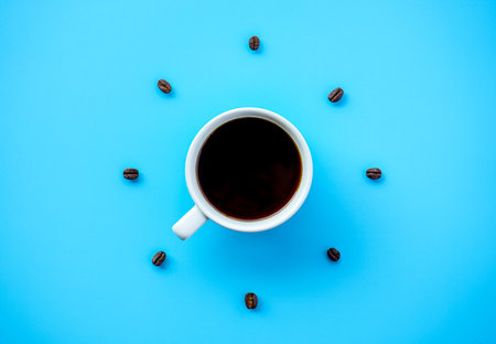 Coffee cup and coffee beans on blue background top view.の写真素材