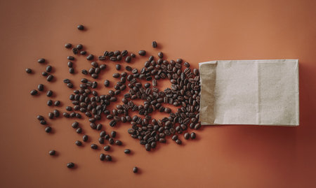 Coffee beans in a paper bag on a brown background.の写真素材